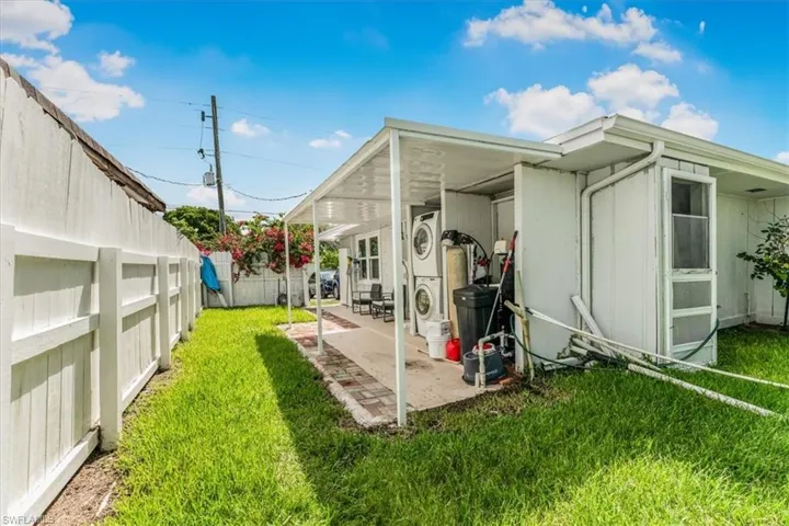 Back of property featuring stacked washing machine and dryer and a patio area