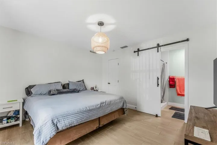 Bedroom with a barn door and light wood finished floors