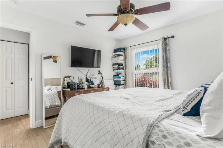 Bedroom with light wood-style flooring, a ceiling fan, and a closet