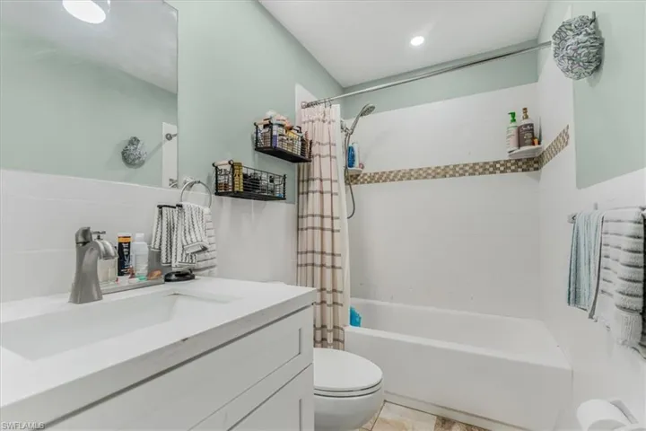 Full bath featuring vanity and shower / tub combo with curtain