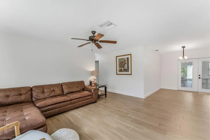 Living area with light wood-type flooring, ceiling fan, and french doors