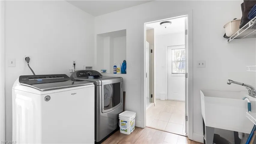 Laundry room with a sink, washer and clothes dryer, and laundry area