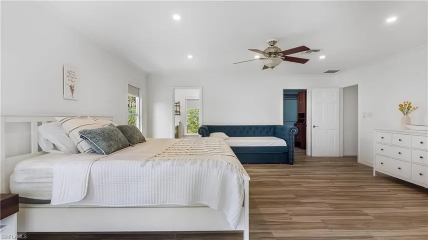 Bedroom with wood finished floors, ornamental molding, visible vents, and recessed lighting