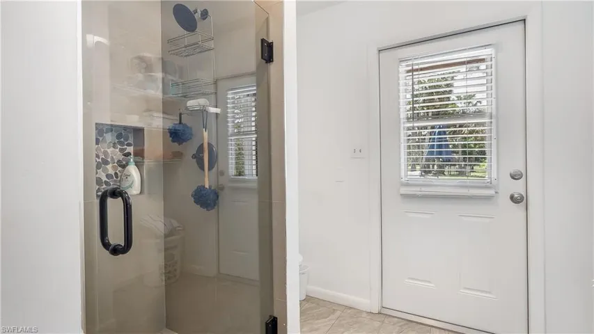 Bathroom featuring tile patterned floors, baseboards, and a stall shower