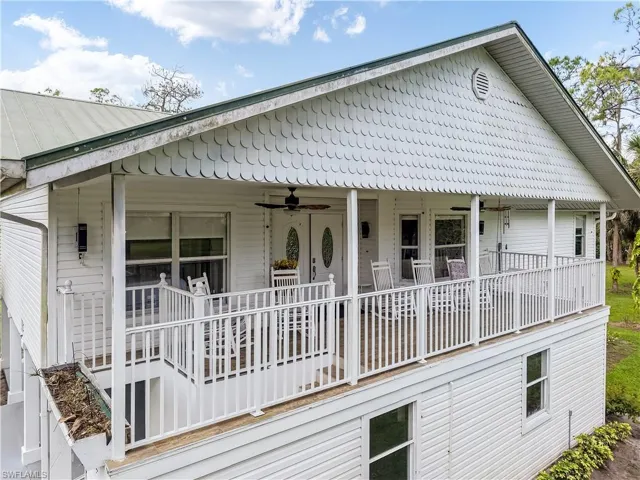 Rear view of house featuring ceiling fan and covered porch