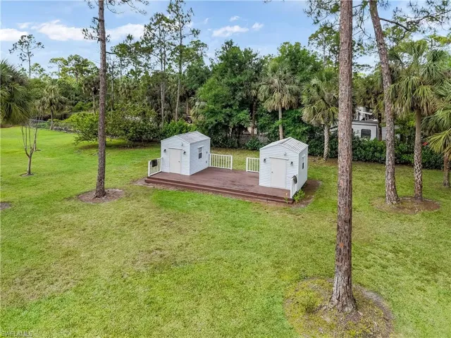View of storm shelter featuring an outbuilding, a storage unit, and a lawn