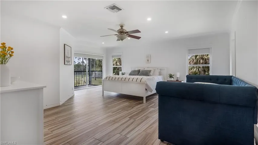 Bedroom featuring light wood-style flooring, access to exterior, multiple windows, and visible vents