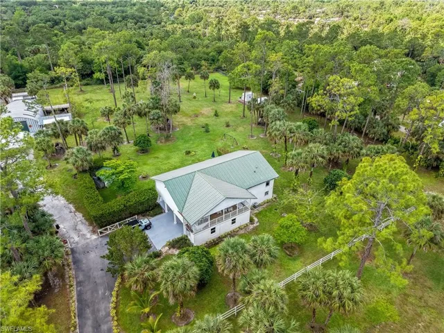 Birds eye view of property featuring a wooded view