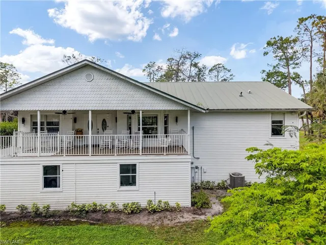 Back of property with metal roof, covered porch, central AC unit, and ceiling fan