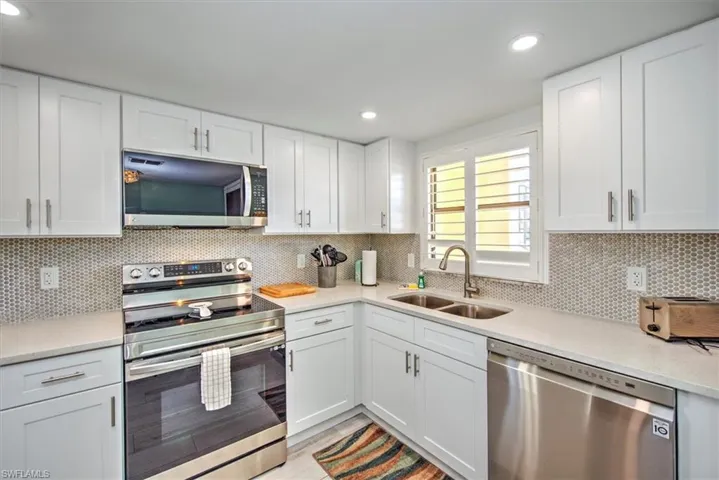 Kitchen with white cabinets, sink, and appliances with stainless steel finishes