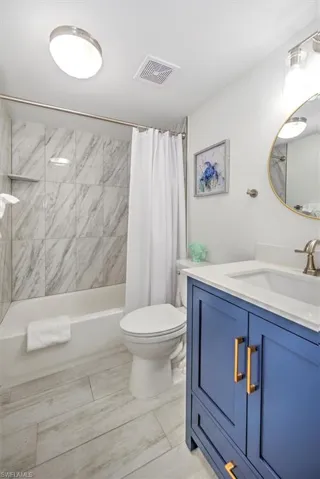 Full bathroom featuring shower / bath combo, toilet, and vanity