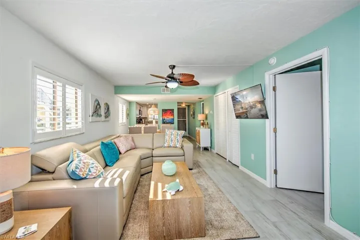 Living room with ceiling fan and light hardwood / wood-style floors