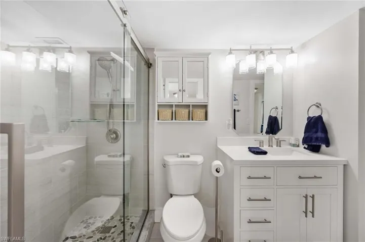 Full bathroom with vanity and a stall shower