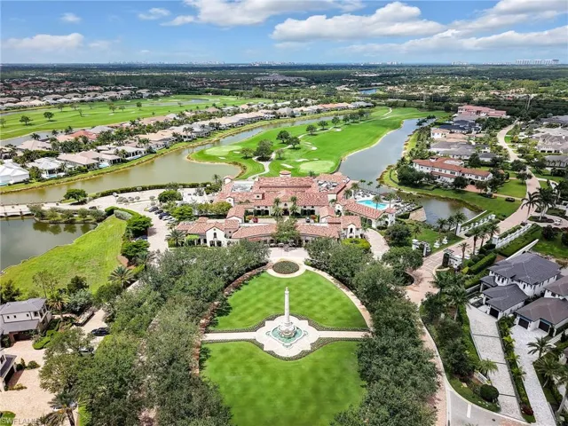 Aerial view of property and surrounding area with nearby suburban area, a local golf course, and a large body of water