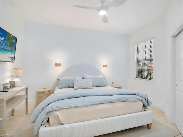Bedroom featuring light wood-style floors, a ceiling fan, and baseboards