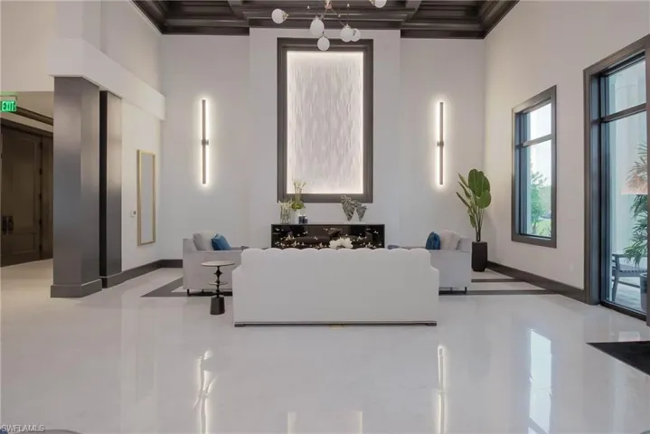 Lobby featuring a high ceiling, marble flooring & decorative lighting