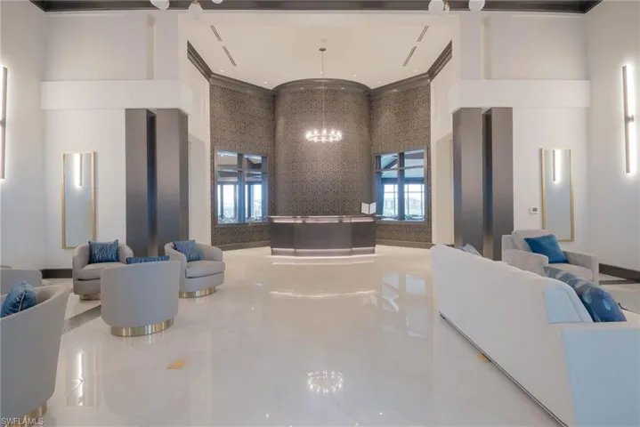 Community lobby featuring a high ceiling, decorative molding, marble flooring