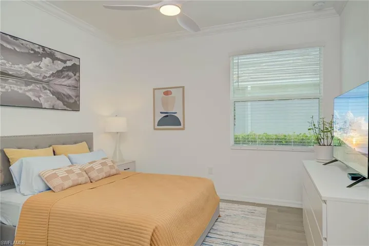 Bedroom with crown molding, a ceiling fan, and wood-style tile floors