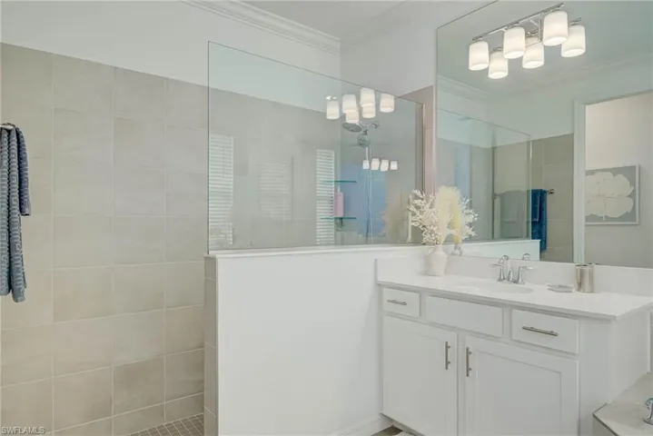 Master Bathroom featuring walk-in shower w/glass divider and beautiful wall tile and crown molding