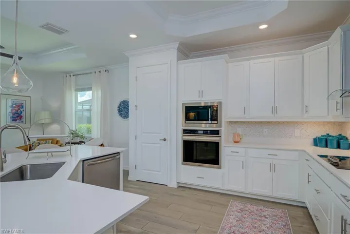 Kitchen with recessed lighting, a raised ceiling, appliances with stainless steel finishes