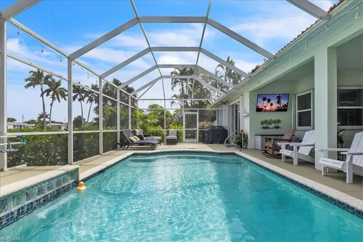 Swimming pool featuring a patio area, a lanai, and grilling area