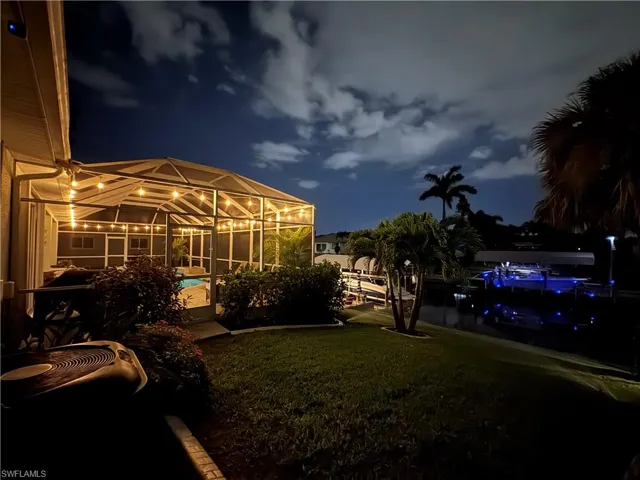Night perspective of rear area featuring a pool and a nearby body of water