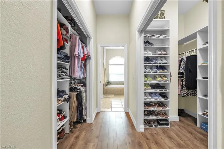 Master Walk in closet with light wood-style laminate flooring