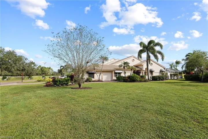 View of front of property with a garage, a lanai, and a front yard