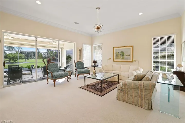 Living room with crown molding, plenty of natural light, and carpet
