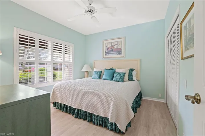 Bedroom with light hardwood / wood-style flooring, a closet, and ceiling fan