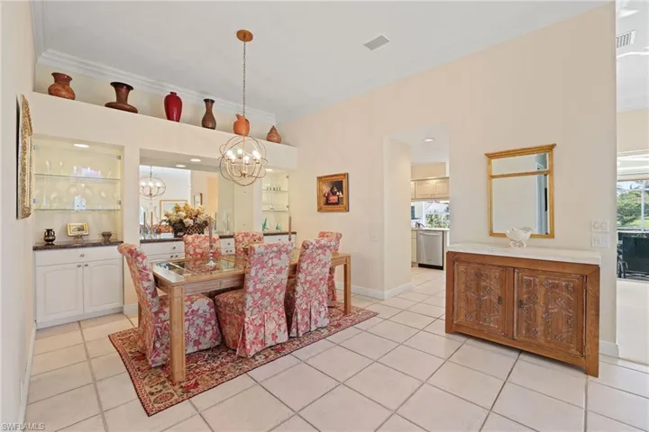 Dining room with crown molding, light tile patterned floors, and a chandelier