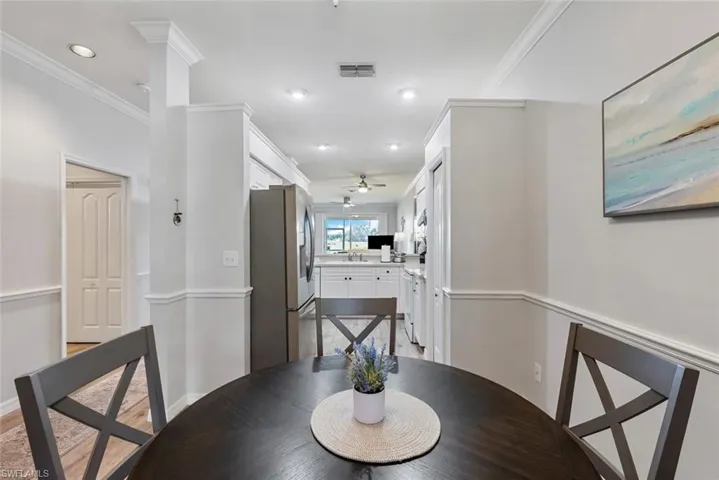 Dining area featuring sink, crown molding, light wood-type flooring, and ceiling fan