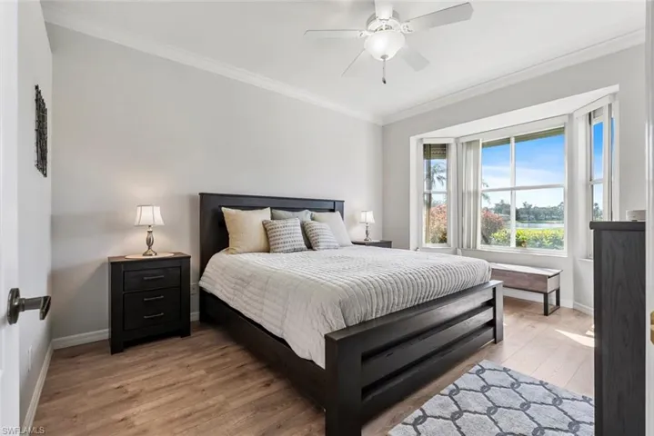 Bedroom featuring crown molding, wood-type flooring, and ceiling fan