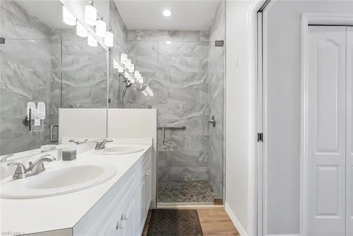 Bathroom with vanity, an enclosed shower, and hardwood / wood-style floors