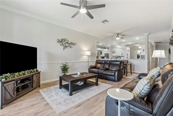 Living room featuring crown molding, light hardwood / wood-style flooring, and ceiling fan