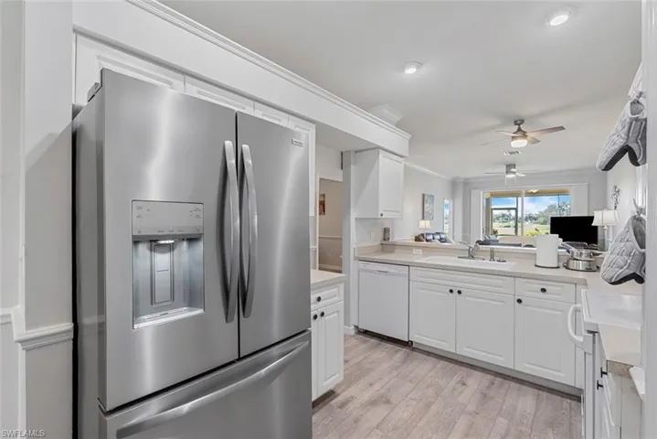 Kitchen featuring light hardwood / wood-style flooring, ornamental molding, white cabinets, white appliances, and ceiling fan