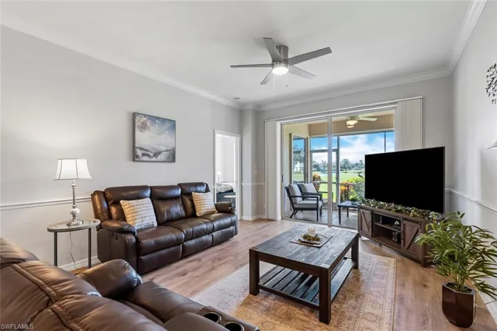 Living room featuring ceiling fan, ornamental molding, and light hardwood / wood-style flooring