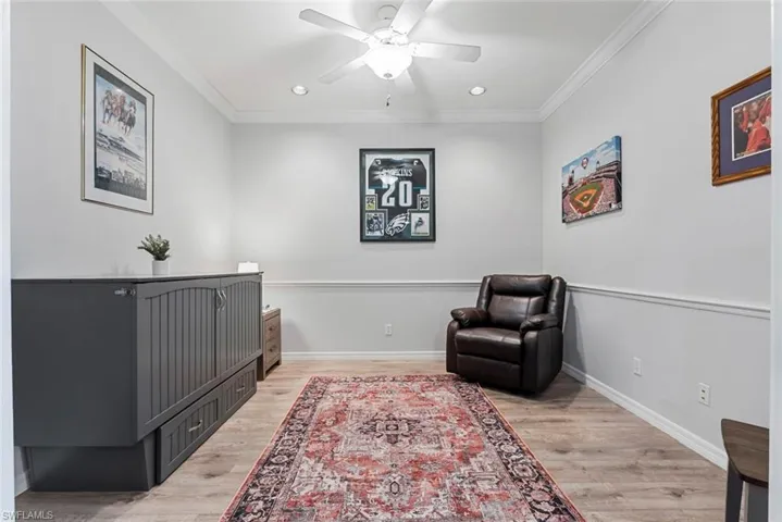 Living area featuring light hardwood / wood-style flooring, ornamental molding, and ceiling fan