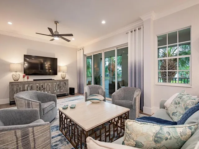 Living room with crown molding, a healthy amount of sunlight, ceiling fan, and light hardwood / wood-style floors