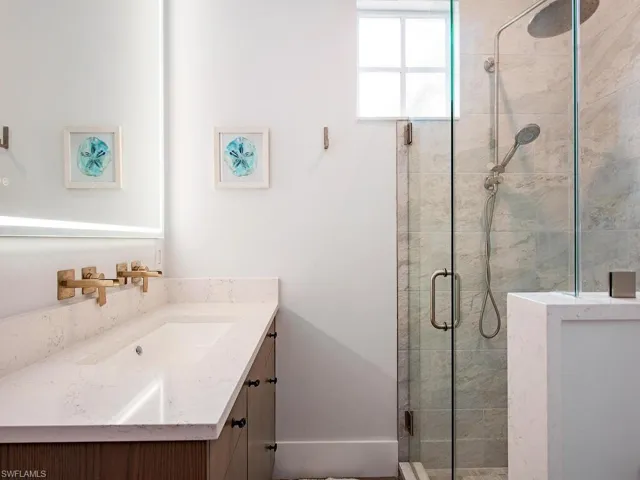 Bathroom featuring a shower with door and vanity