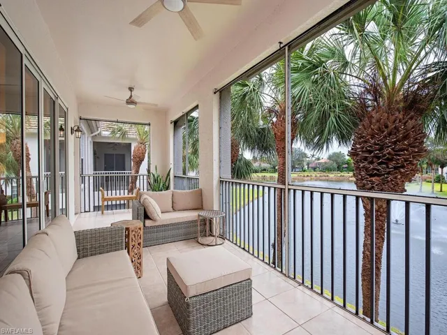 Sunroom / solarium with ceiling fan and a water view