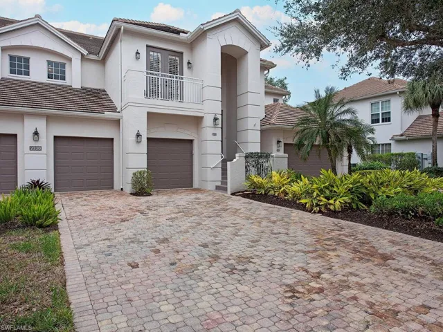 View of front of home with a garage and a balcony