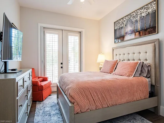 Bedroom featuring ceiling fan, access to outside, multiple windows, and wood-type flooring