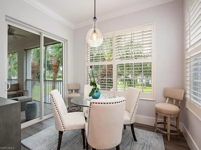 Dining area with crown molding, wood-type flooring, and a wealth of natural light