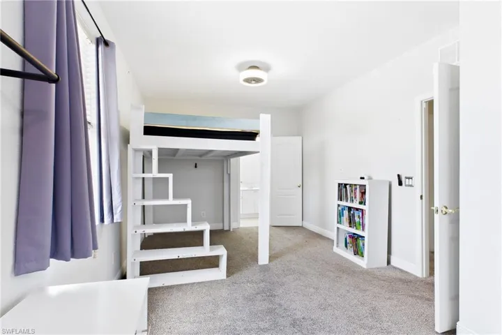 Neutral wall tones, carpeted flooring, and a flush-mount ceiling light fixture
