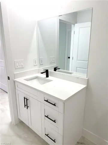 Bathroom with vanity and light marble finish floors