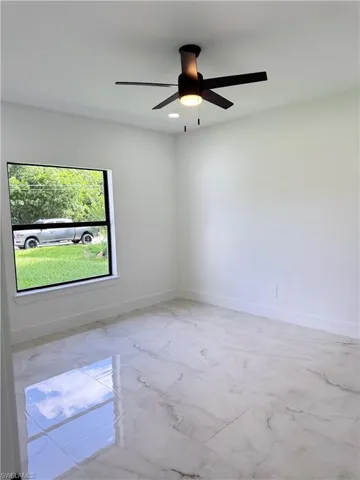Unfurnished living room featuring light marble finish flooring, a glass covered fireplace, and recessed lighting