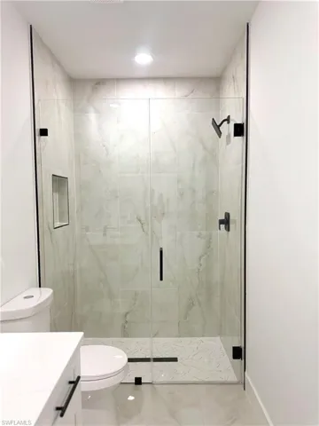 Unfurnished bedroom with light marble finish flooring, a ceiling fan, and a closet