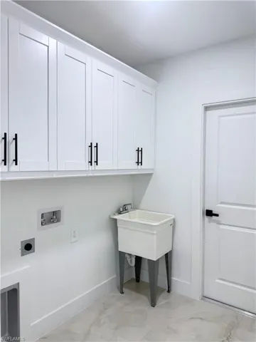 Laundry area with cabinet space, washer hookup, and hookup for an electric dryer