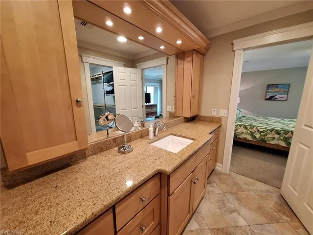 Bathroom featuring tile flooring, crown molding, and vanity
